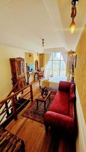 a bedroom with a bed and a red couch at Kali Tibba Resort Chail in Chail