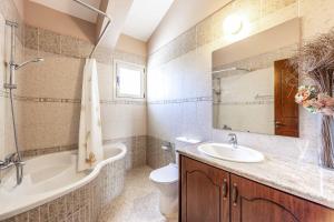a bathroom with a sink and a tub and a toilet at Villa Vasilissa in Argaka +23 photos