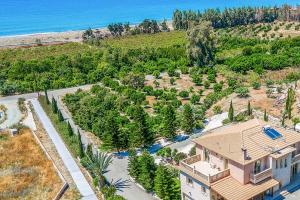 an aerial view of a house with trees and the ocean at Villa Vasilissa in Argaka
