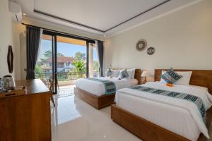 a bedroom with two beds and a balcony at Sari Bungalow in Ubud