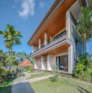 an exterior view of a house with palm trees at Sari Bungalow in Ubud