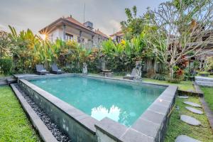 a swimming pool in the yard of a house at Sari Bungalow in Ubud