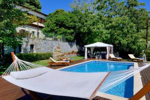 uma rede em frente a uma piscina em Villa Kerasia em Miléai