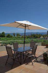 a table and chairs with an umbrella on a patio at Hotel Maracaibo in Portonovo