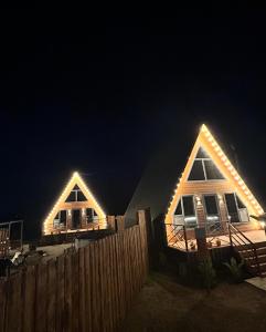 two houses with lights on them at night at Zhaltyr resort in Astana