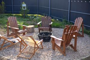 three rocking chairs and a fire pit in a yard at Zhaltyr resort in Astana