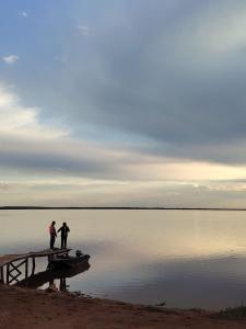 two people standing on a dock near a body of water at Zhaltyr resort in Astana +1 photo