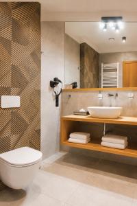 a bathroom with a sink and a toilet and a mirror at Hotel Szara Willa in Opole