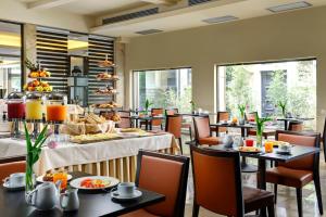 restauracja ze stołami i krzesłami z jedzeniem w obiekcie FH55 Grand Hotel Mediterraneo we Florencji