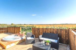 a man and a woman in a hot tub on a patio at Hideaway by Liv Retreats in Lincoln