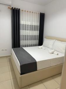 a bedroom with a large bed with black curtains at Hotel Luis in Durrës