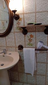 a bathroom with a sink and a mirror and towels at LV SWAN Apartment in Carloforte