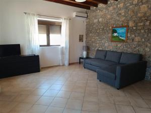 a living room with a couch and a tv at The Old barrel houses in Kythira