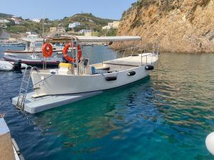 a white boat is docked in the water at Hotel La Baia in Ponza