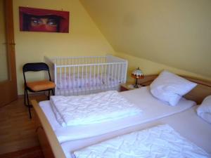 a bedroom with two beds and a chair and a painting at Apartment kleine Robbe in Büsum