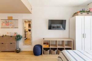 a bedroom with a tv on a white wall at Studio Home Madrid in San Sebastián de los Reyes