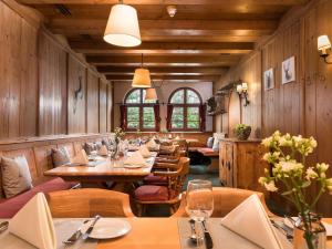 a restaurant with wooden walls and tables and chairs at Sunday Hotel Garmisch Partenkirchen in Garmisch-Partenkirchen