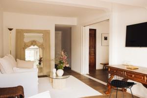 a living room with a white couch and a table at Grand Hôtel De Cala Rossa & Spa Nucca in Porto-Vecchio