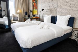 two beds in a hotel room with white sheets at Les Nuits in Antwerp +55 photos