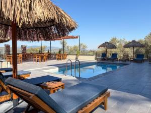 a resort pool with chairs and umbrellas and tables at Ephesus Select Suites in Kuşadası
