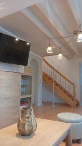 a living room with a table and a tv and stairs at Generations Holiday City Lofts am Neumarkt Kölner Straße 23a in Attendorn