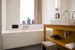 a white bathroom with a tub and a sink at Les Nuits in Antwerp