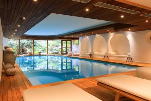 a swimming pool in a house with a large window at Grand Hôtel De Cala Rossa & Spa Nucca in Porto-Vecchio