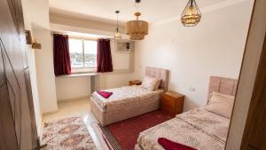 a small room with two beds and a couch at Anuket House in Naj‘ al Maḩaţţah +16 photos