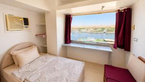 a bedroom with a bed and a window at Anuket House in Naj‘ al Maḩaţţah