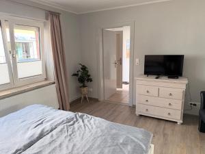 a bedroom with a bed and a television on a dresser at Ferienwohnung am Binnensee 2 in Heiligenhafen