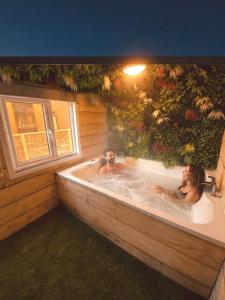 two people in a jacuzzi tub in a building at Hideaway by Liv Retreats in Lincoln
