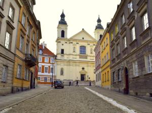 une vieille rue avec un bâtiment avec une église dans l'établissement Studio Stare Miasto, à Varsovie