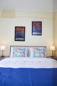 a bedroom with a blue bed with two pictures on the wall at Apartments Holiday in Perea