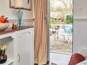 a sliding glass door leading to a patio with a table at Apple Bough Cottage in Hereford +27 photos