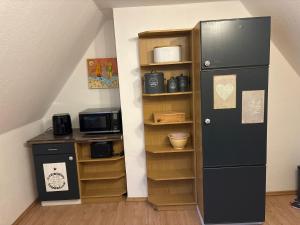 a kitchen with a black refrigerator and a shelf at Ferienwohnung Seestern-Ranch in Niederlangen