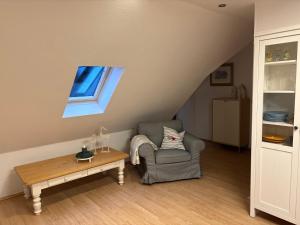 a living room with a chair and a table at Ferienwohnung Seestern-Ranch in Niederlangen