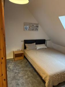 a small bedroom with a bed and a night stand at Ferienwohnung Seestern-Ranch in Niederlangen