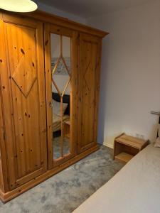 a bedroom with a wooden cabinet with a mirror at Ferienwohnung Seestern-Ranch in Niederlangen +11 photos