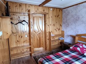 a bedroom with wooden walls and a bed in a room at "Різьб'ярська садиба" in Slavske +79 photos
