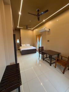 a bedroom with a bed and a table and chairs at JRR room stay in Thiruvaiyāru