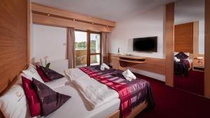 Habitación de hotel con cama y TV en Hotel Corvus Aqua, en Orosháza