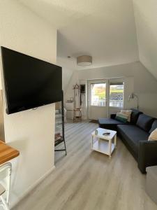 a living room with a couch and a flat screen tv at Burgerblick in Brodersby