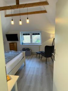 a bedroom with a bed and a desk and a chair at Burgerblick in Brodersby