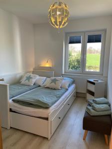 a bedroom with a large bed and a chandelier at Burgerwiese in Brodersby