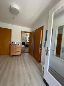 an empty living room with a dresser and a door at Burgerwiese in Brodersby