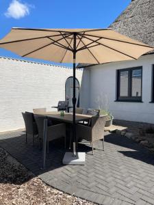 a table and chairs under an umbrella on a patio at Burgerwiese in Brodersby