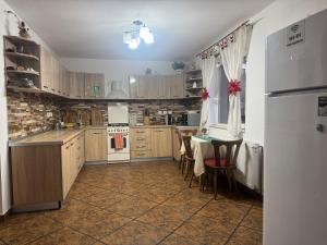a kitchen with a table and a white refrigerator at Villa Bran Legend in Bran