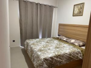 a bedroom with a bed and a curtain at Nice and calm place in Moka
