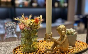 a gold statue of a man next to a vase with flowers at DORMERO Hotel Fürth in Fürth