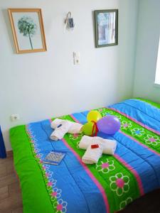 a bed with a colorful blanket with toys on it at Alkistis Apartments, 1st floor in Agios Kirykos
